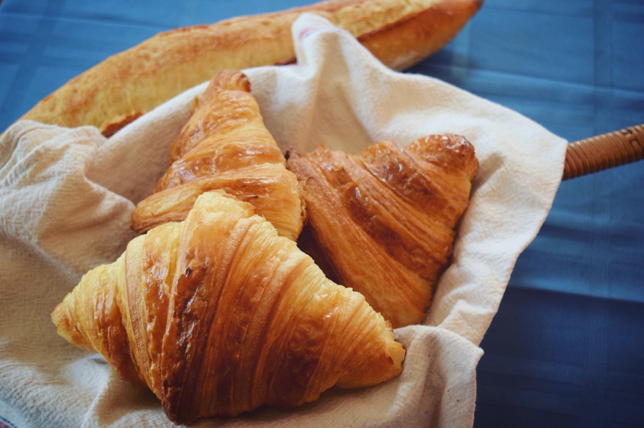 Golden brown croissants served on a linen cloth in a basket