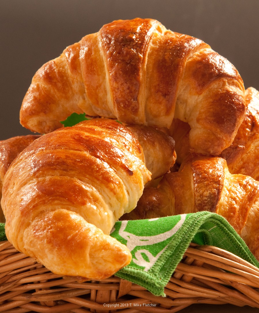 Glossy golden brown croissants in a basket